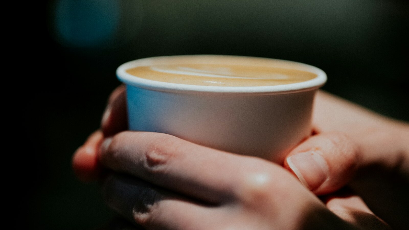 Hands wrapped around a warm cup of coffee